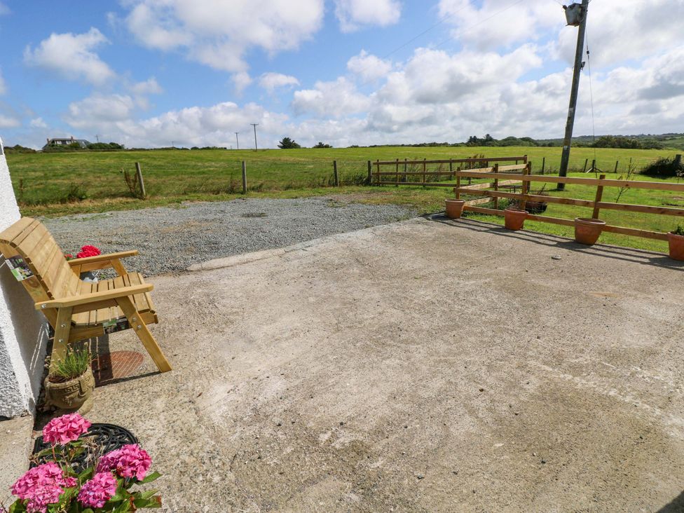 An outdoor area with a bench and gravel at Coach House Cottage