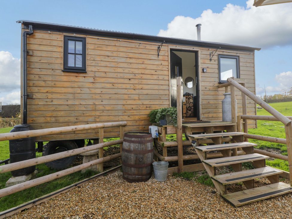 A wooden cabin with steps and railing at Wiltshire Weavers Hut Sutton Benger near Christian Malford