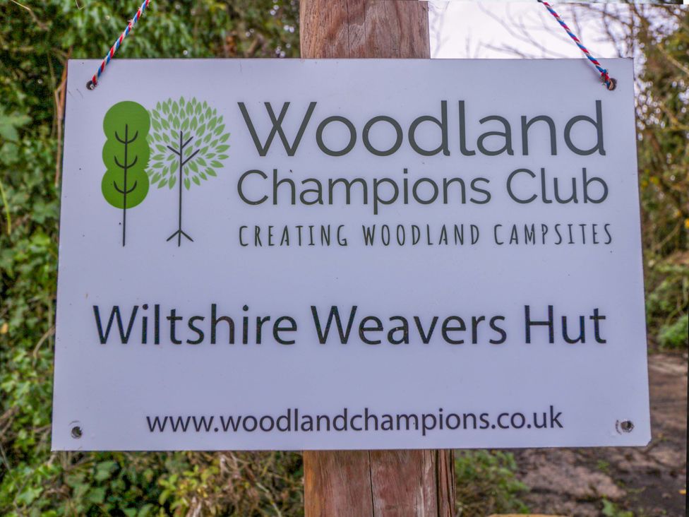 A sign indicating Wiltshire Weavers Hut and Woodland Champions Club