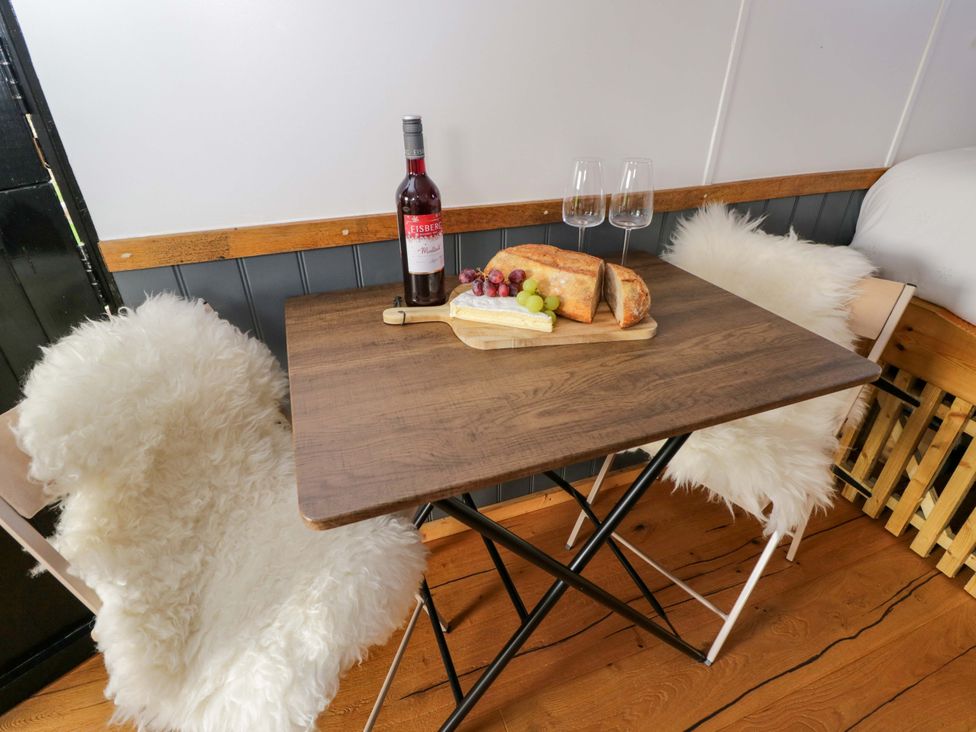 A dining area with a table set for two at Wiltshire Weavers Hut Sutton Benger near Christian Malford