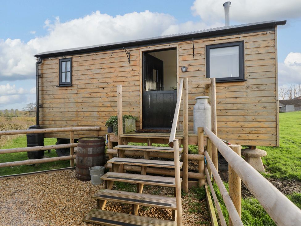 A wooden hut with steps and a fence at Wiltshire Weavers Hut in Sutton Benger near Christian Malford