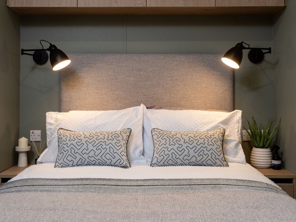 A bedroom with a bed and bedside lamps at Arlington 40 x 14 Two Bed