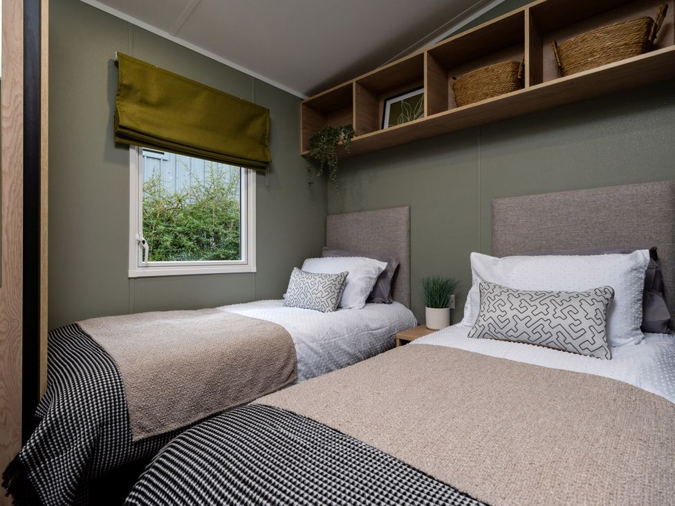 A bedroom with two beds and a window at Arlington 40 x 14 Two Bed