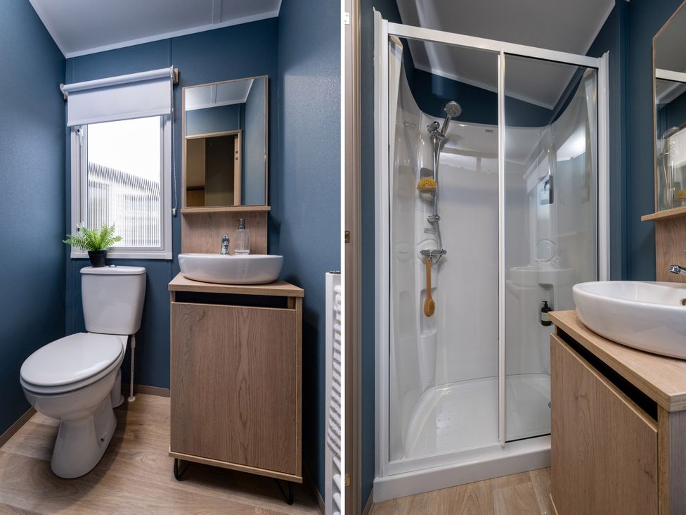 A bathroom with a toilet, basin, and shower at Arlington 40 x 14 Two Bed