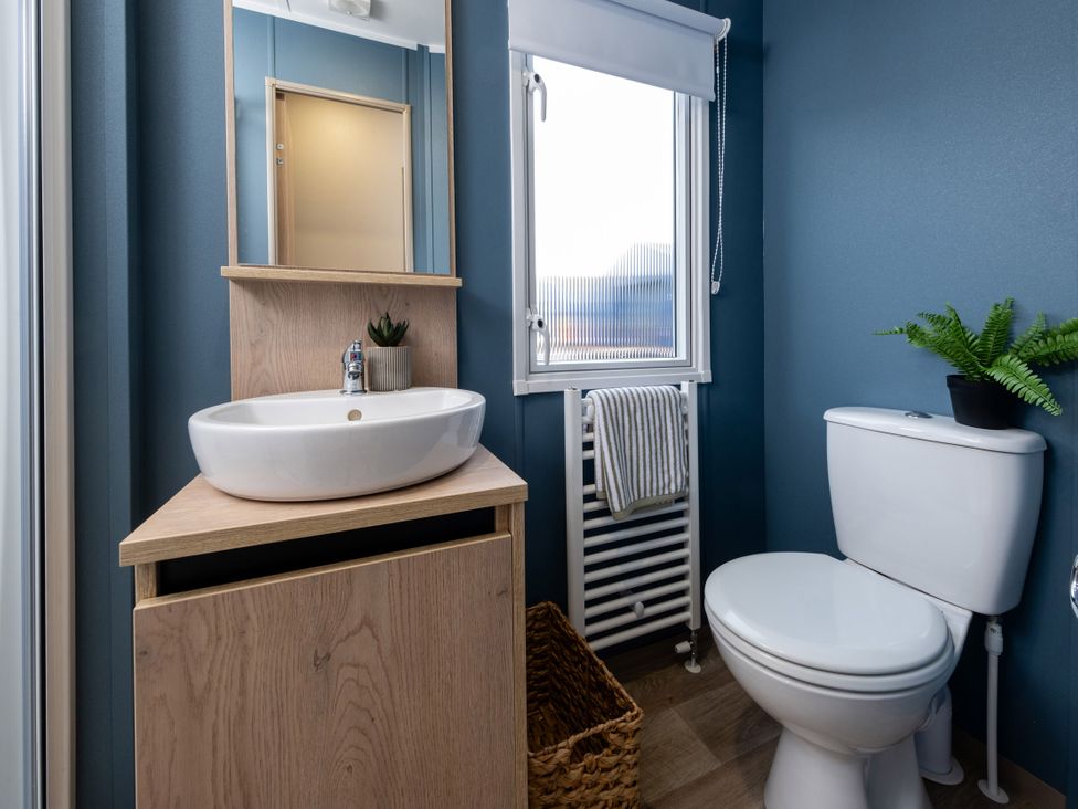 A bathroom with a sink, toilet and mirror at Arlington 40 x 14 Two Bed 