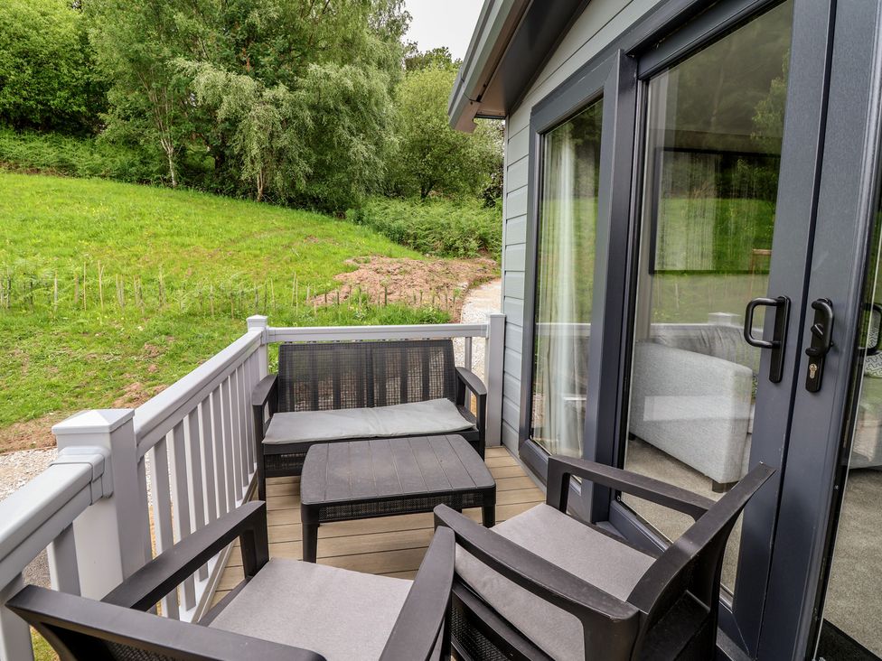 An outdoor seating area with chairs and a table at The Pines 2 Bedrooms in Delamere