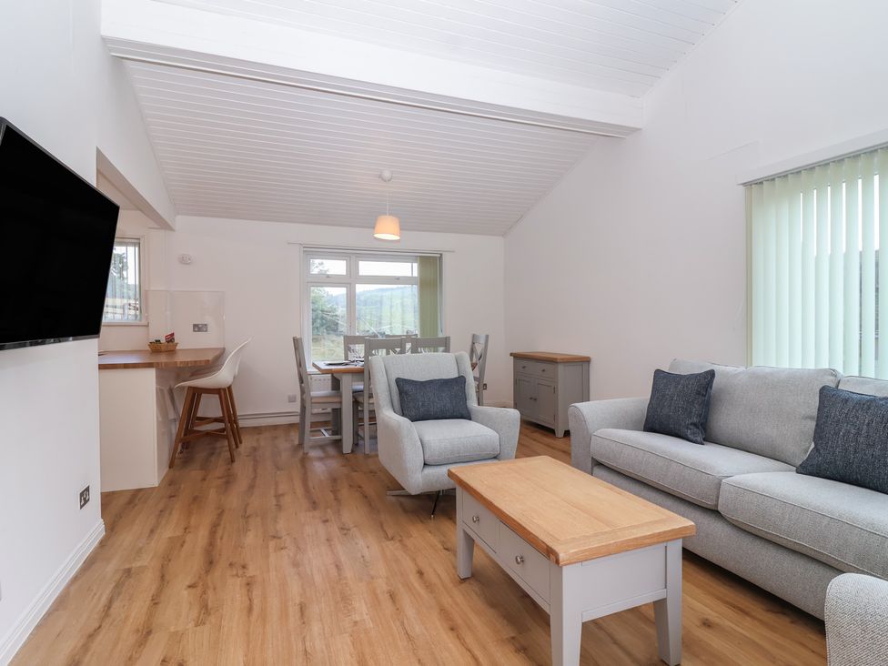 A living room with a sofa and dining table at Harcombe House Bungalow 25 in Chudleigh