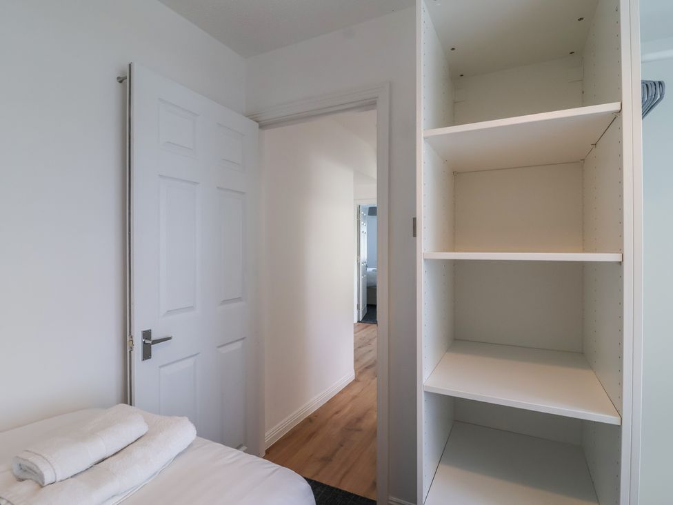 A bedroom with towels on a bed and a door leading to another room at Harcombe House Bungalow 25 Chudleigh