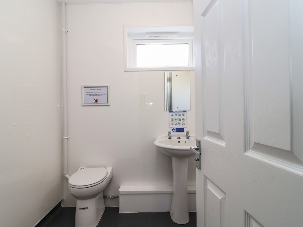 A bathroom with a toilet and sink at Harcombe House Bungalow 25 Chudleigh