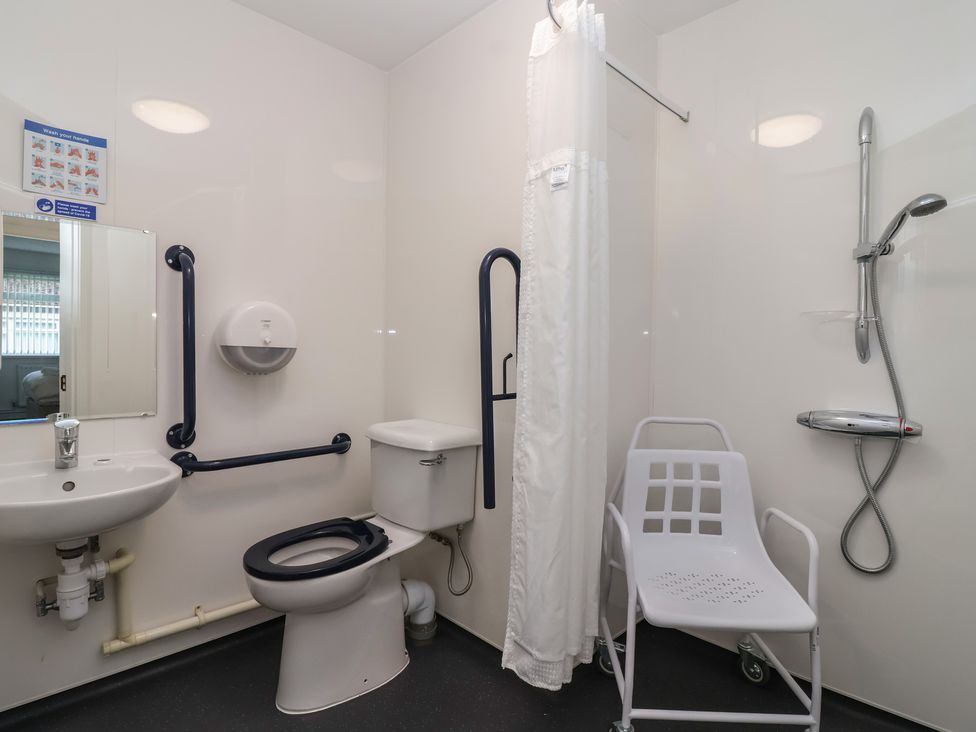 A bathroom with a toilet, sink, and shower at Harcombe House Bungalow 25 Chudleigh