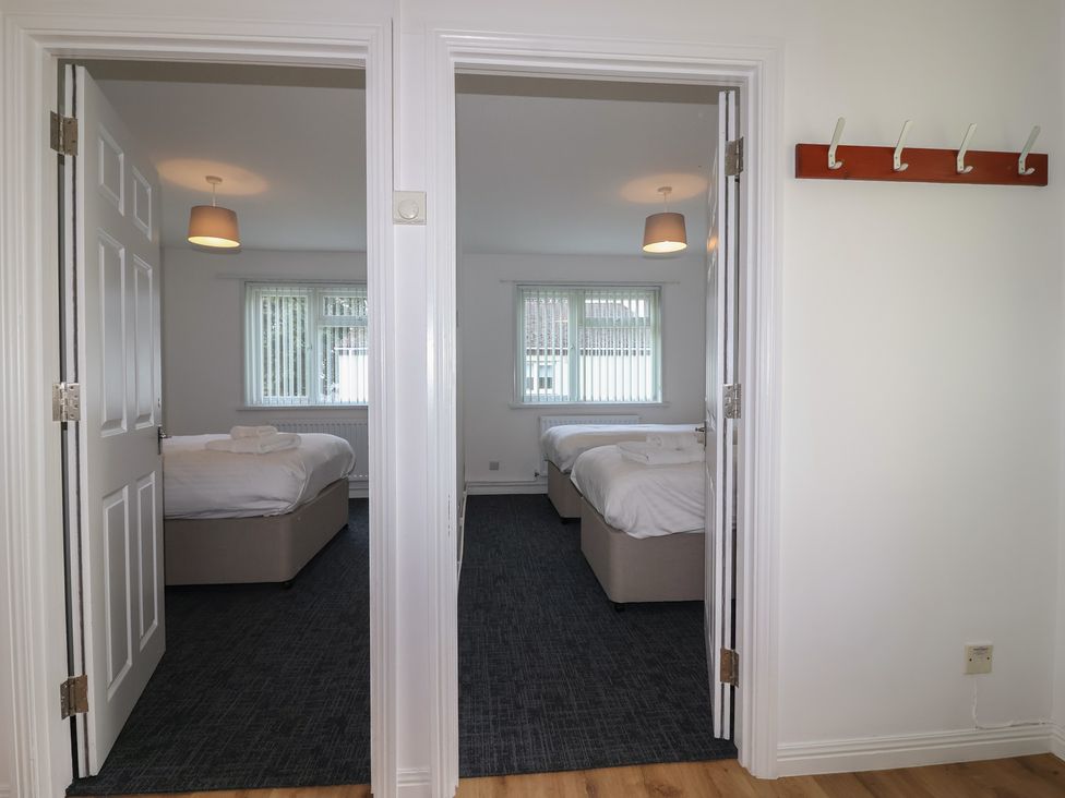 A view of two bedrooms with beds and windows at Harcombe House Bungalow 25 Chudleigh