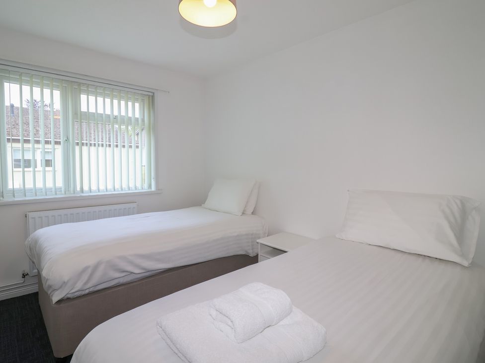 A bedroom with two beds and a window at Harcombe House Bungalow 25 in Chudleigh