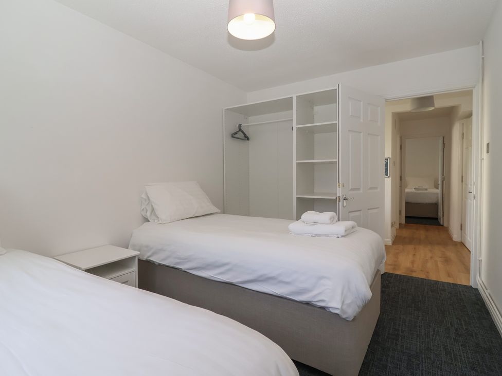 A bedroom with two beds and a wardrobe at Harcombe House Bungalow 25 Chudleigh