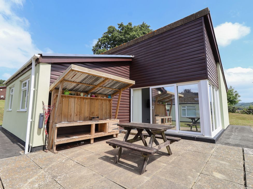 An outdoor area with a picnic table and shelter at Harcombe House Bungalow 25 Chudleigh