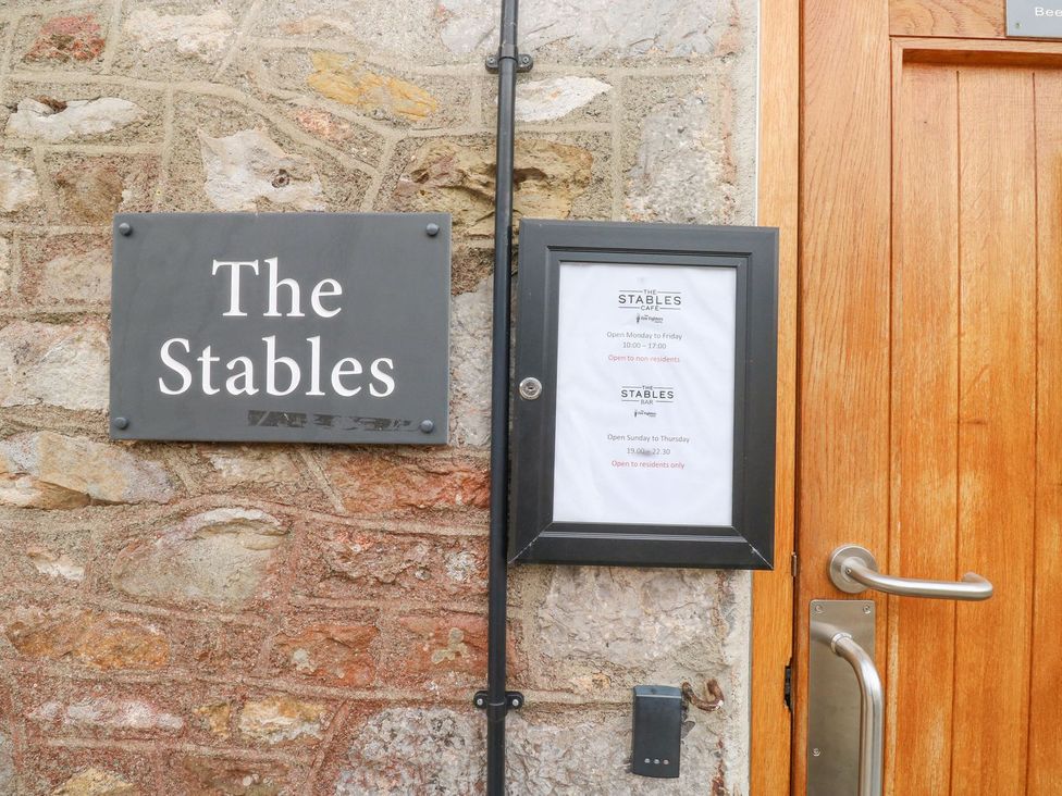 A sign and menu on the wall next to a door at The Stables in Chudleigh