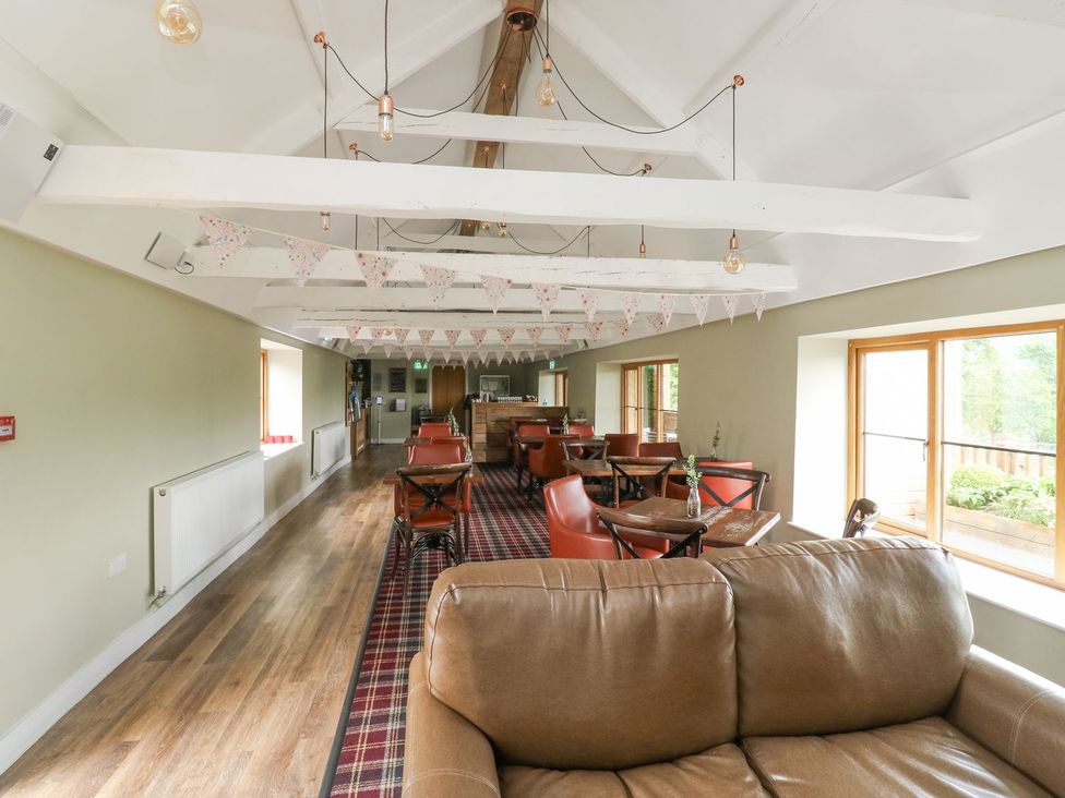 A common area with tables and chairs at Harcombe House Bungalow 25 Chudleigh