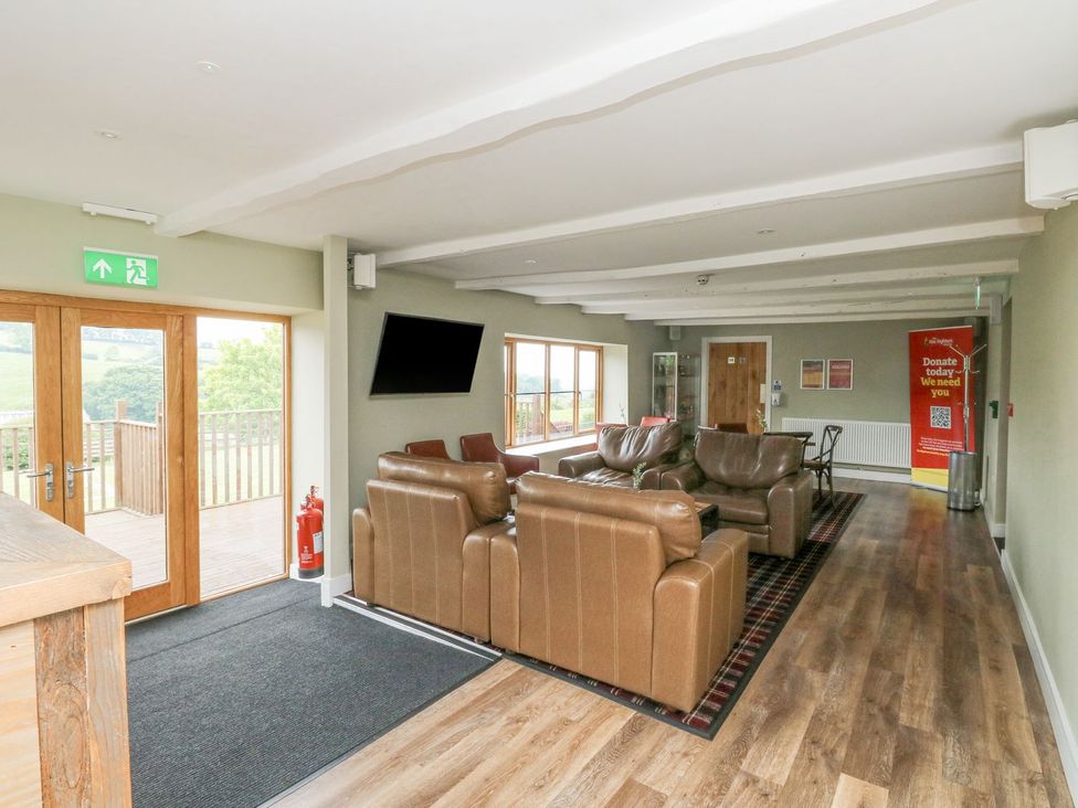 A living room with sofas and a television at Harcombe House Bungalow 25 in Chudleigh