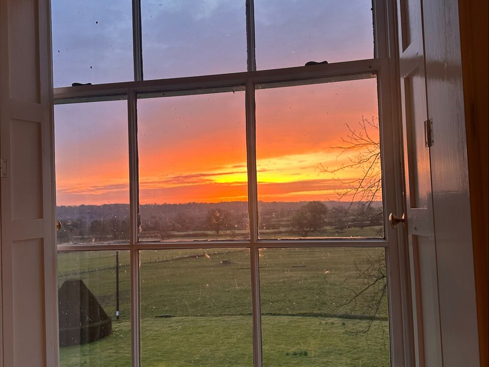 A view of sunset through a window at Farnah House Barn in Duffield