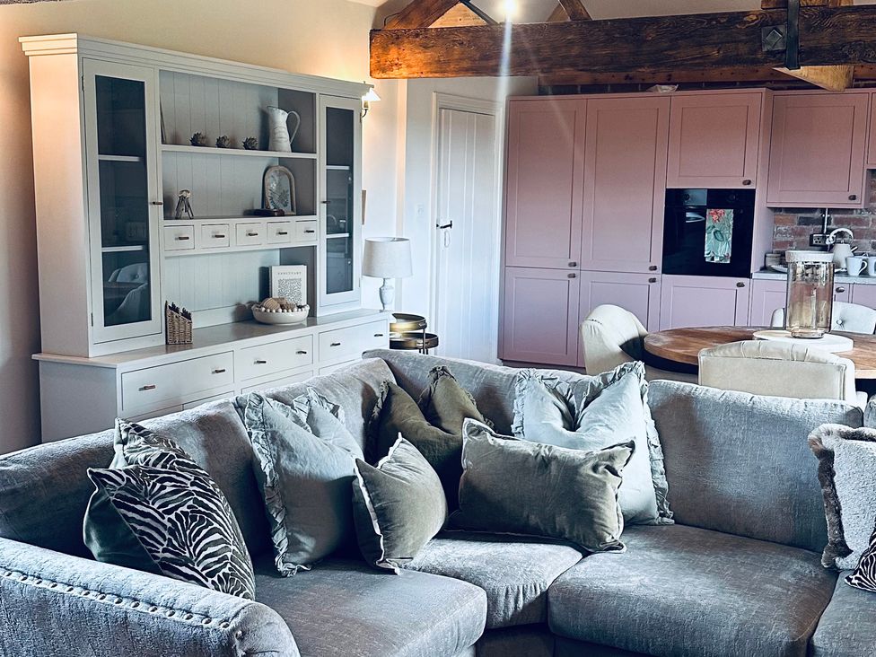 A living room with a sofa and cabinet at Farnah House Barn in Duffield