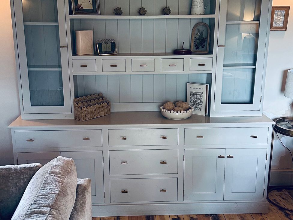 A cabinet with shelves and drawers in the living room at Farnah House Barn in Duffield