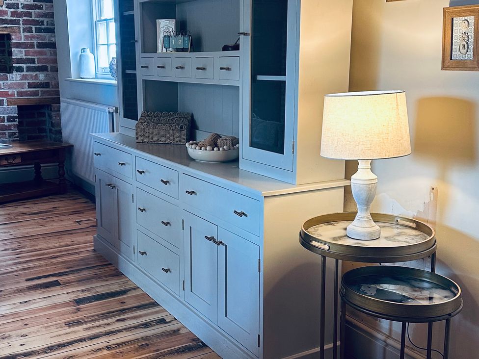 A living room with a cabinet and lamp at Farnah House Barn in Duffield