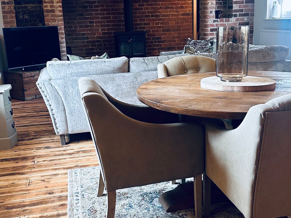 A living room with a round table and chairs at Farnah House Barn in Duffield
