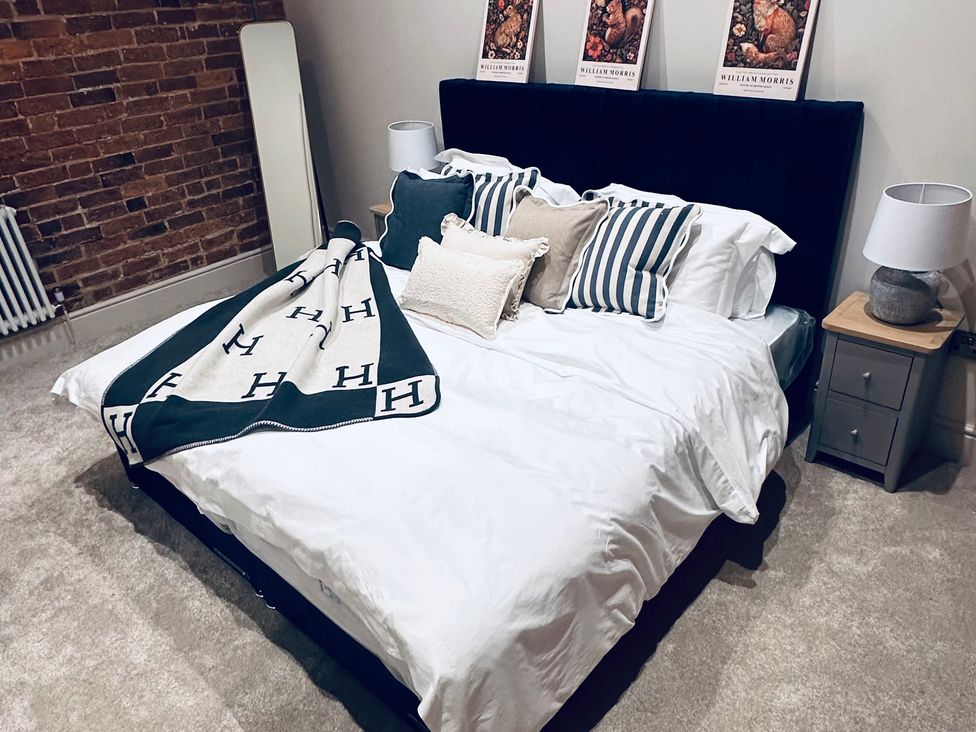 A bedroom with a bed and decorative pillows at Farnah House Barn in Duffield