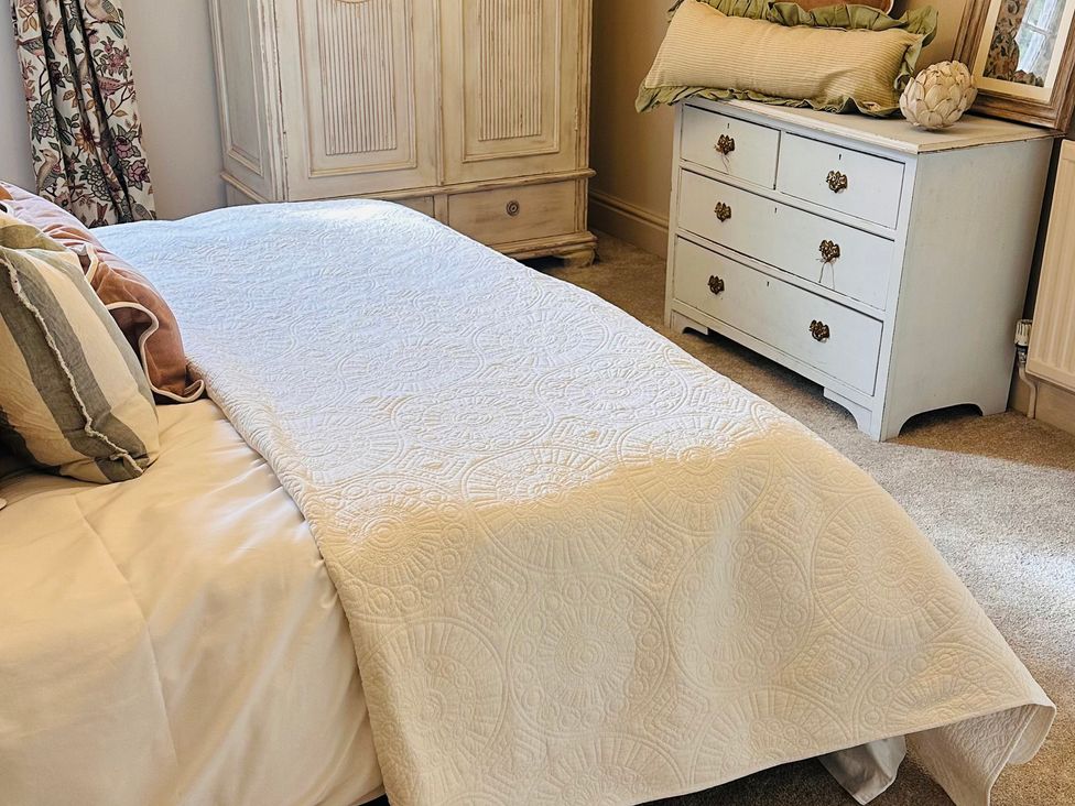 A bedroom with a bed and dresser at Farnah House Barn Duffield