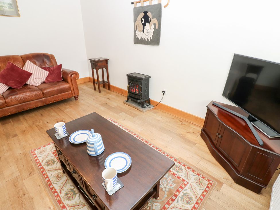 A living room with a sofa, coffee table, and television at Bridge House