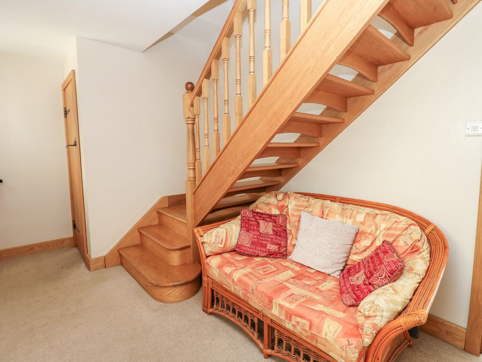 A hallway with a staircase and a sofa at Bridge House