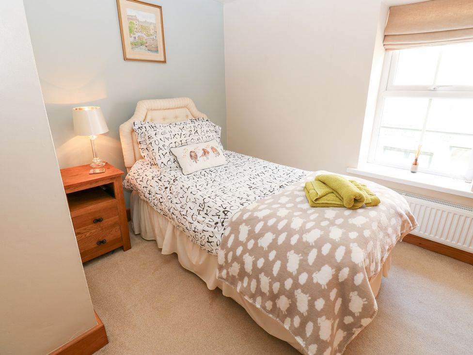 A bedroom with a bed, lamp, and nightstand at Bridge House