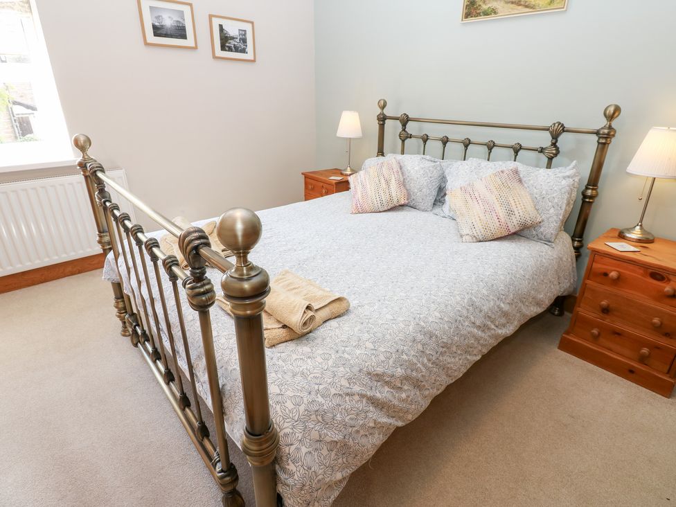 A bedroom with a bed and bedside tables at Bridge House