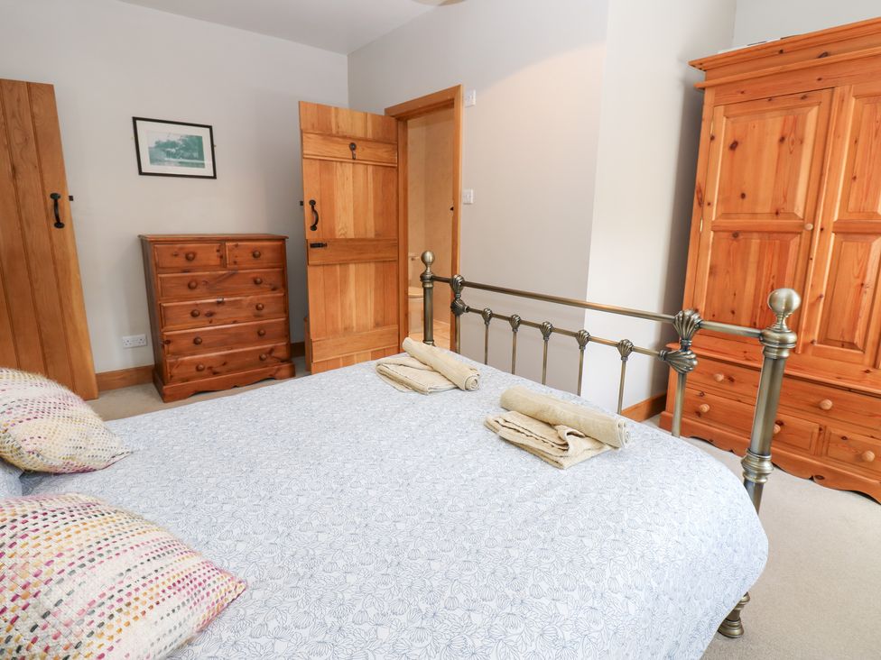 A bedroom with a bed and wooden furniture at Bridge House