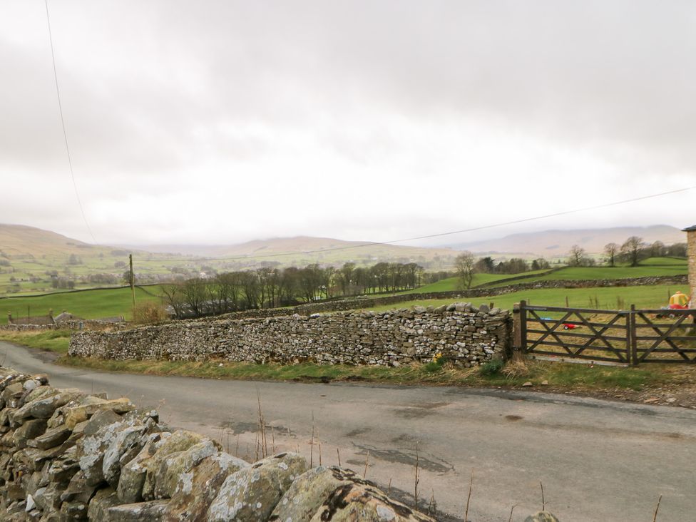 A road with a stone wall and fields at Bridge House