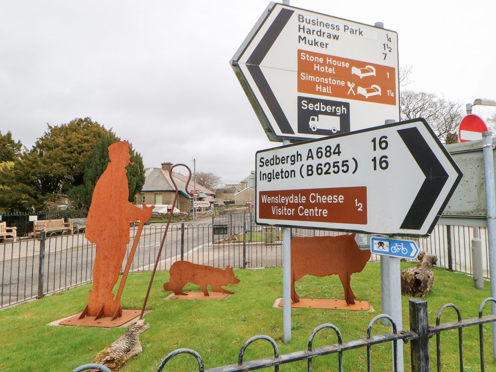 A signpost with direction signs and metal sculptures at Bridge House