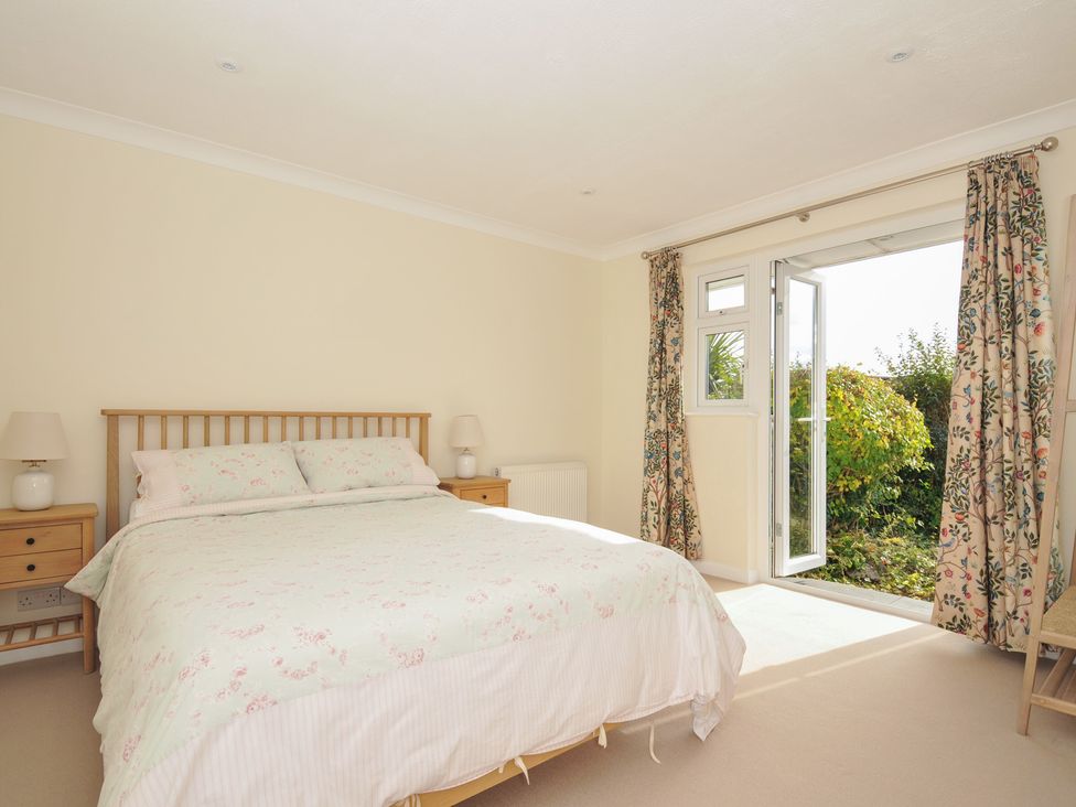 A bedroom with a bed and door leading to the garden at 42 Little Trelyn Wadebridge
