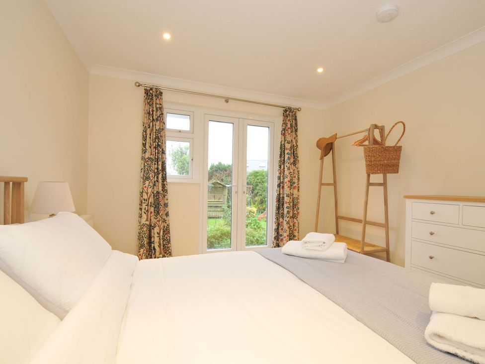 A bedroom with a bed and windows at 42 Little Trelyn in Rock