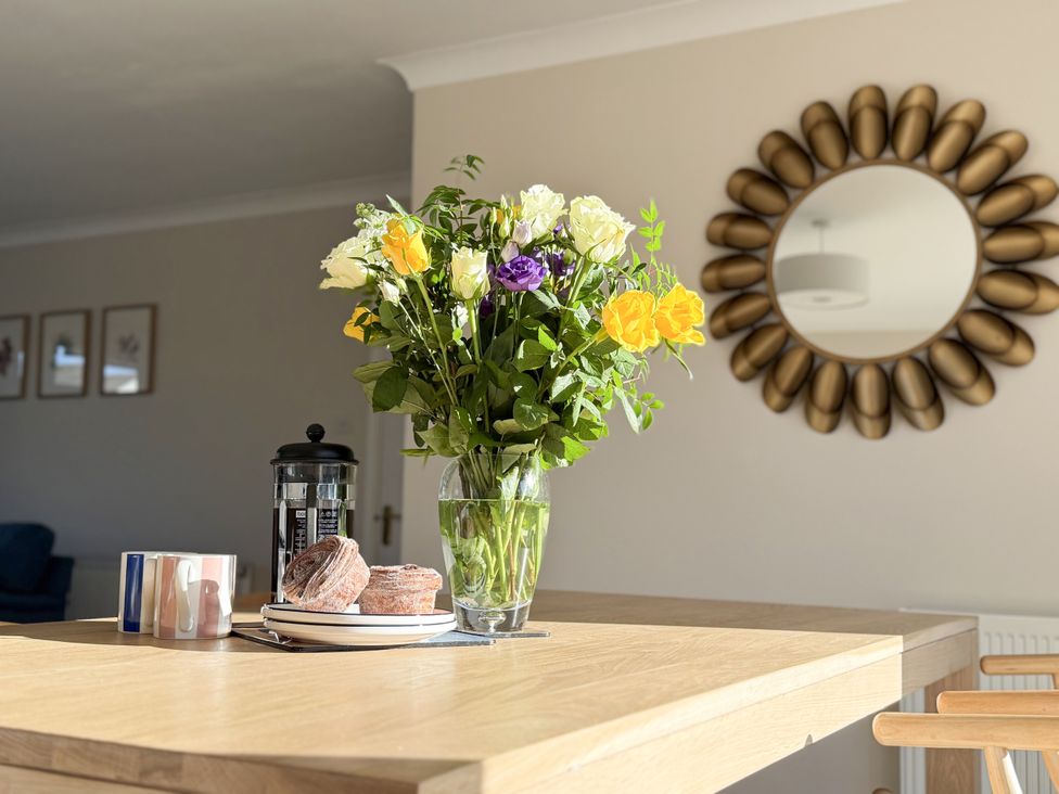 A kitchen with a flower vase and French press on a table at 42 Little Trelyn in Rock