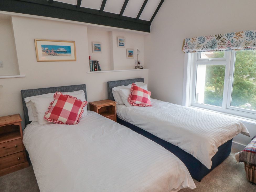A bedroom with two beds and artwork on the wall at Iveridge in Sandsend
