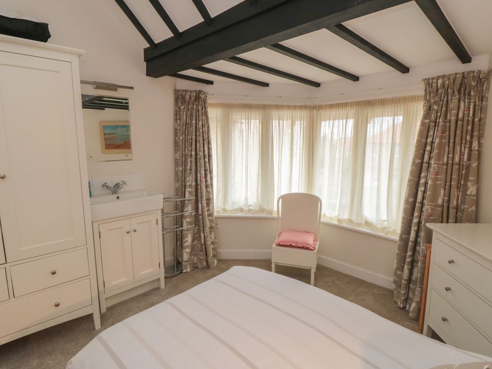 A bedroom with a bed, sink, and wardrobe at Iveridge in Sandsend