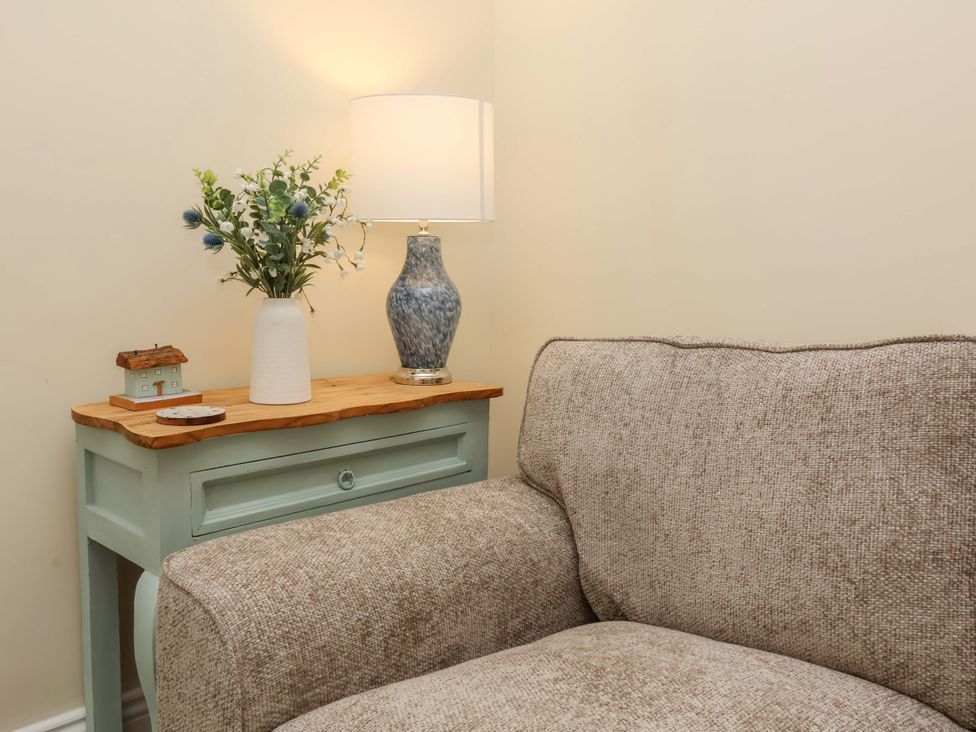 A living room with a sofa and table lamp at Zide the Zea in Hele Bay, Ilfracombe
