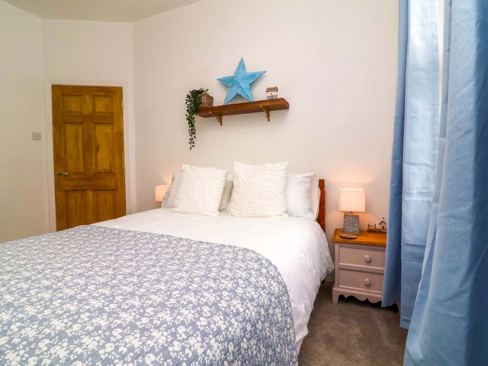 A bedroom with a bed and decorative items at Zide the Zea, Hele Bay, Ilfracombe