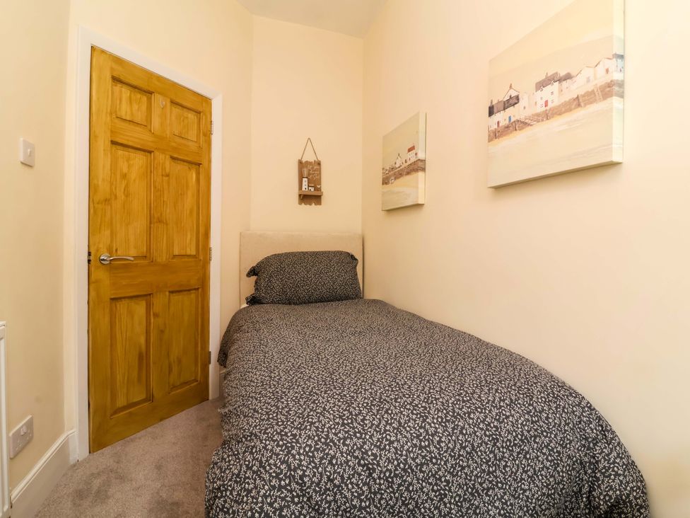 A bedroom with a bed and wall art at Zide the Zea, Hele Bay, Ilfracombe