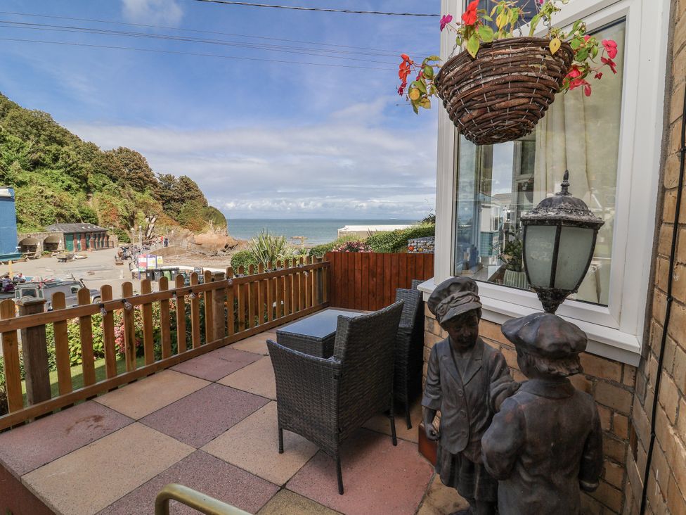 An outdoor patio with table and chairs overlooking the sea at Zide the Zea, Hele Bay, Ilfracombe