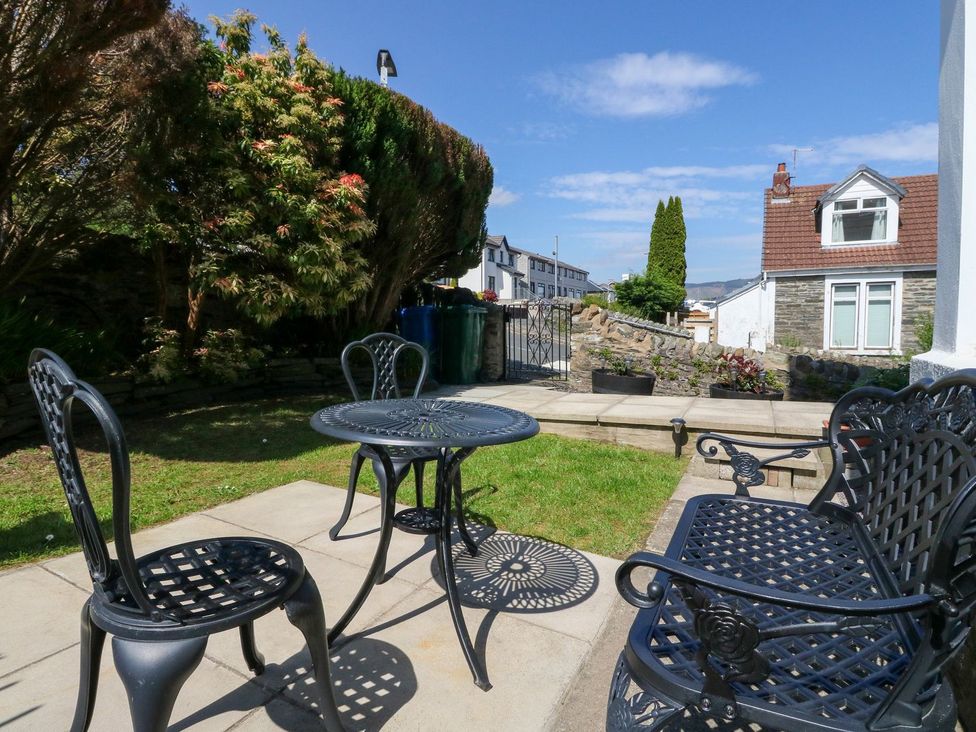 A small garden with metal chairs and a table on a patio at Lenas Corner in Dunoon
