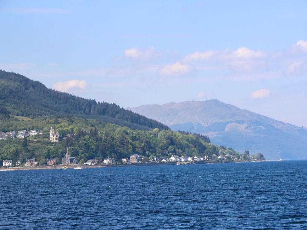 A coastline with houses trees and mountains along a body of water at Lenas Corner in Dunoon