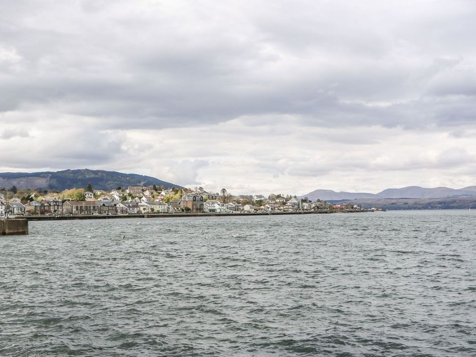 A coastal town with houses and hills in the background by the water at Lenas Corner in Dunoon
