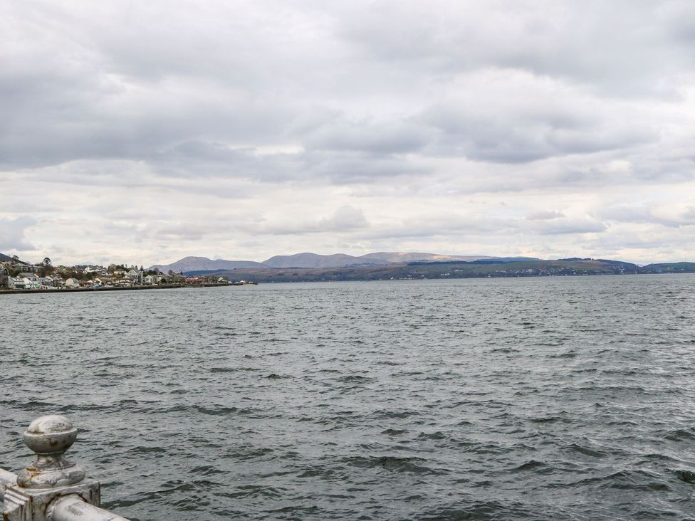 A view of a body of water with houses along the shoreline and hills in the background at Lenas Corner in Dunoon
