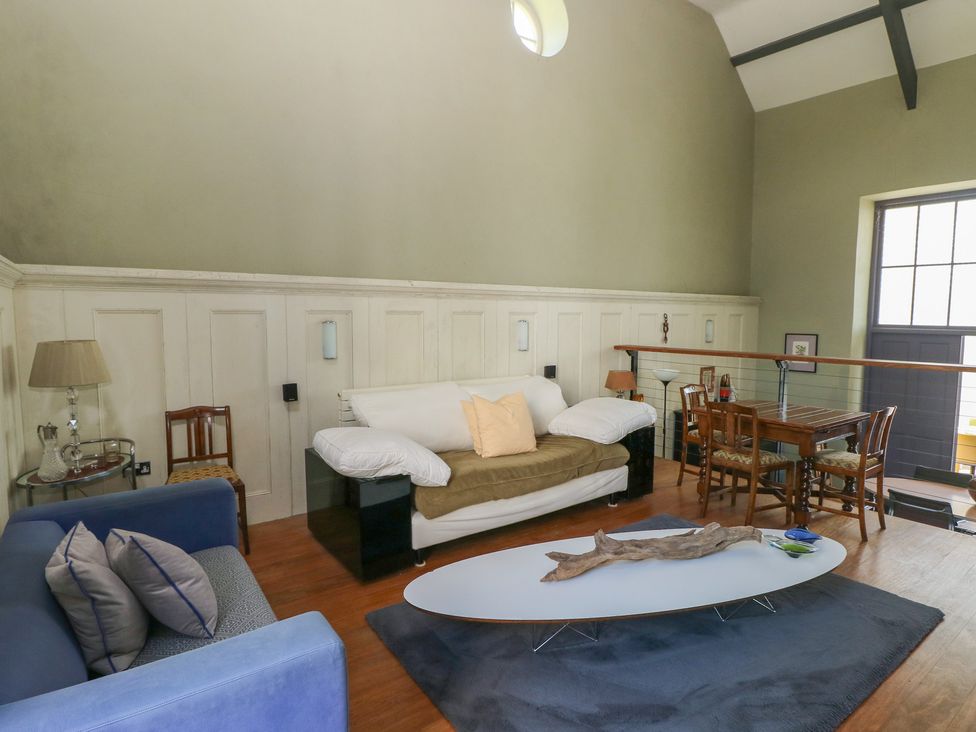 A sitting room with sofas a coffee table and a dining table at Zoar Chapel in Carew