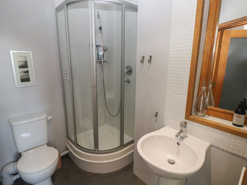 A bathroom with a toilet shower enclosure sink and wooden framed mirror at Zoar Chapel in Carew